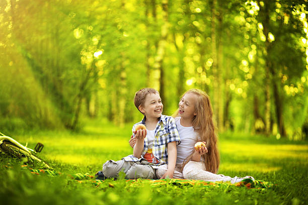 Happy children sitting in the summer park