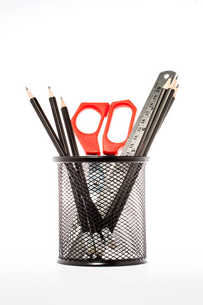 istock Pencils, ruler and scissors in holder. Isolated on white backgro 497691565