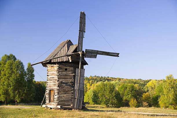 Wind turbine standing on the edge of the autumn forest