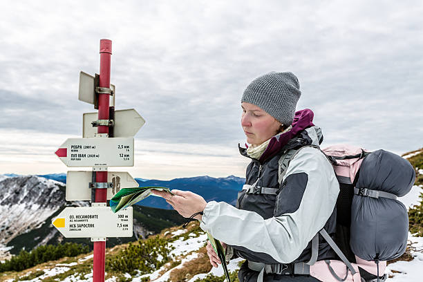 istock woman looking for right way on map in mountains 497703736