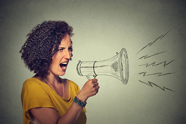 istock angry screaming young woman holding megaphone 497706258
