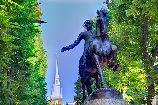 Boston, Massachusetts, USA - January 22, 2024: Rear view of the equestrian statue of George Washington in the Boston Public Garden. The sculpture by Thomas Ball was commissioned in 1859, modeled in 1864, and cast and dedicated in 1869. The bronze statue measures approximately 22 x 6 x 15 ft, and rests on a granite base. The monument was conceived in an effort to present Massachusetts as an artistic center. Back Bay neightborhood buildings in the background.