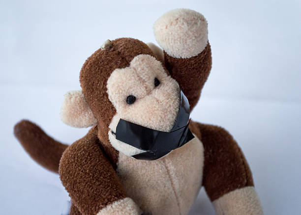 istock Child's Monkey Toy Raising Hand/Asking a Question Tape Over Mouth 497708598