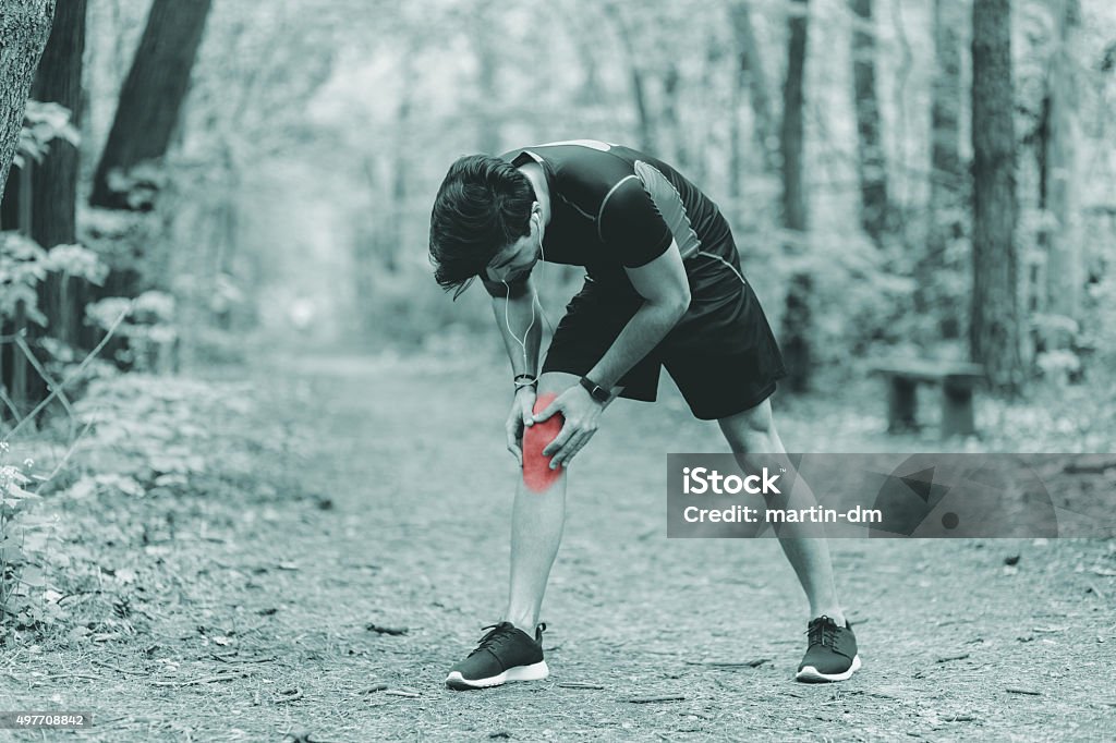 Man with knee fracture Sportsman with injured leg in the park 2015 Stock Photo