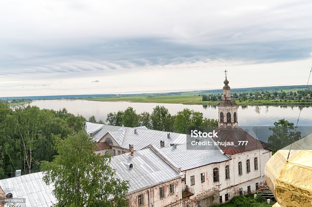 Top view on ancient church with river in background Ancient church on Sukhona River embankment with gold cupola in foreground. Veliky Ustyug, Vologodsky region, Russia. Ancient Stock Photo
