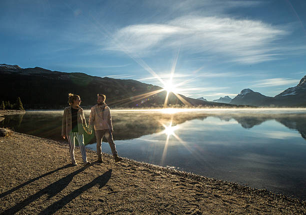 istock Young couple walking on lake shore at sunrise 497709120