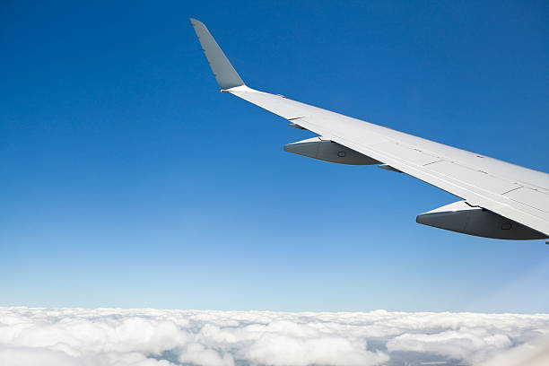 istock Airplane Wing with Winglet Banks Against Blue Sky with Clouds 497709273