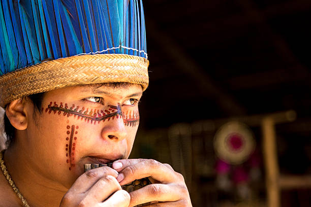 Native Brazilian playing wooden flute Native Brazilian man playing wooden flute at an indigenous tribe in the Amazon amazonas state brazil photos stock pictures, royalty-free photos & images