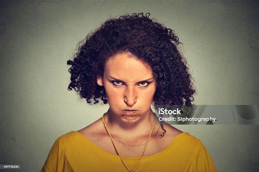 angry woman upset, about to have nervous breakdown Closeup portrait of angry young woman, nervous, upset, about to have nervous atomic breakdown isolated on gray wall background. Negative human emotions facial expression feelings attitude Anger Stock Photo