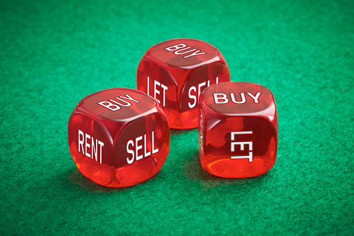 Housing market concept, three red dice on a green felt background.