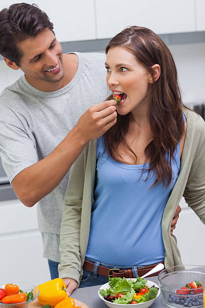 istock Man feeding his wife cherry tomato 497710531