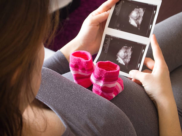 Mulher grávida olhando para raios-x imagem de Bebé - fotografia de stock