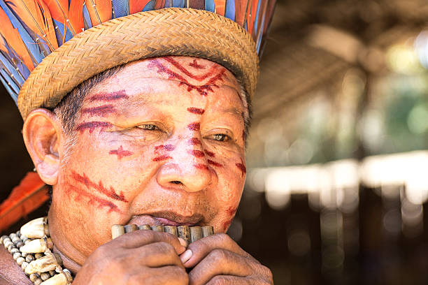 istock Native Brazilian old man playing wooden flute 497710798