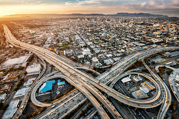 Freeway interchanges at dusk Helicopter point of view of Los Angeles highway interchanges at golden hour. Many details are visible in the image. los angeles aerial stock pictures, royalty-free photos & images