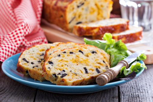 Savory cheese loaf with olives on cutting board