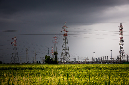 voltage pylons in a field of wheat during a thunderstorm