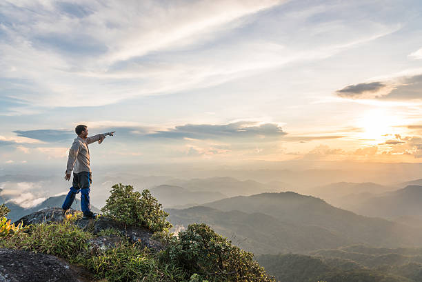 istock man point his hand to the sun on top mountain 497714020