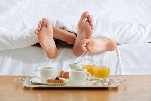 カップルのベッドでの朝食とトレイ - bed couple human foot heterosexual couple ストックフォトと画像