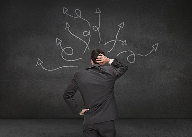 istock Doubtful businessman looking at arrows 497714565
