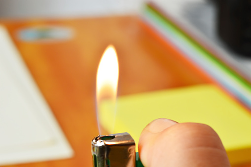 lighter flame lit by a finger