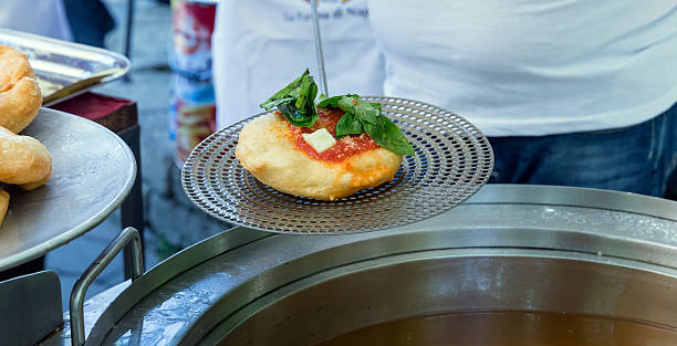 Fried Pizza Pizza Fritta (deep fried pizza dough) prepared in a huge pan full of oil. Pizza Fritta (along with regular pizza) is a traditional Naples dish and one of the most common street foods. The full version includes salsa, mozzarella and a lot of basil. italie stock pictures, royalty-free photos & images