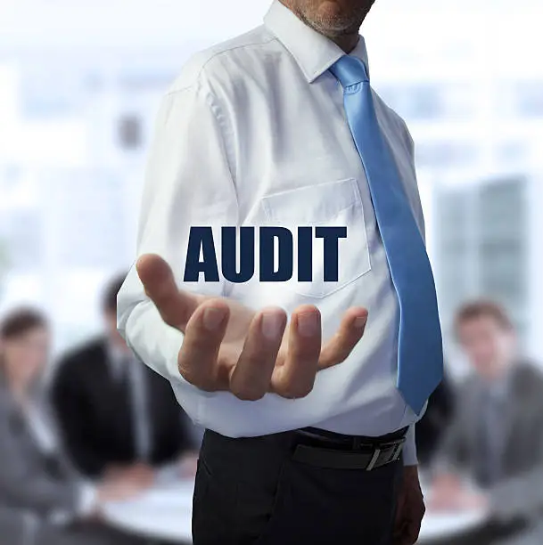 Photo of Elegant businessman holding the word audit