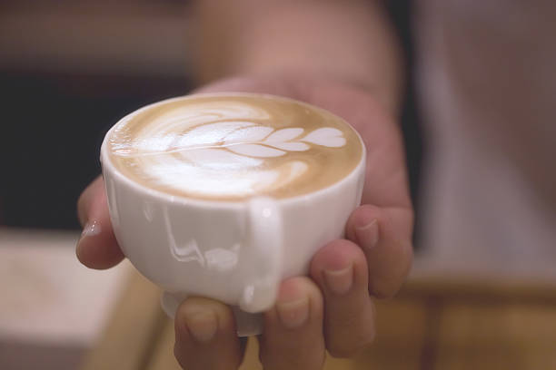 istock Charming young man enjoying aroma coffee in cafe 497716418