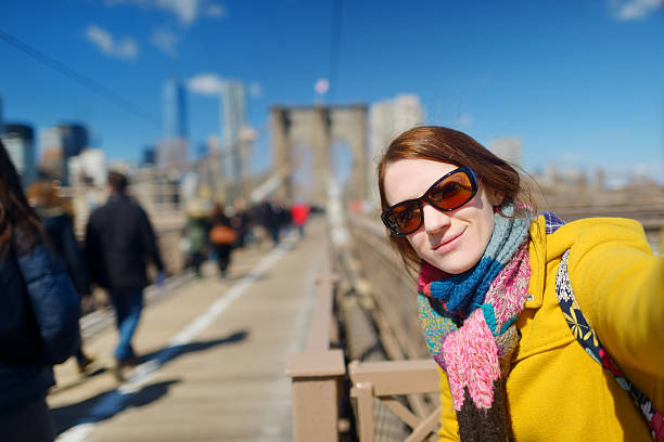 istock Young woman taking a selfie on Brooklyn Bridge 497750786