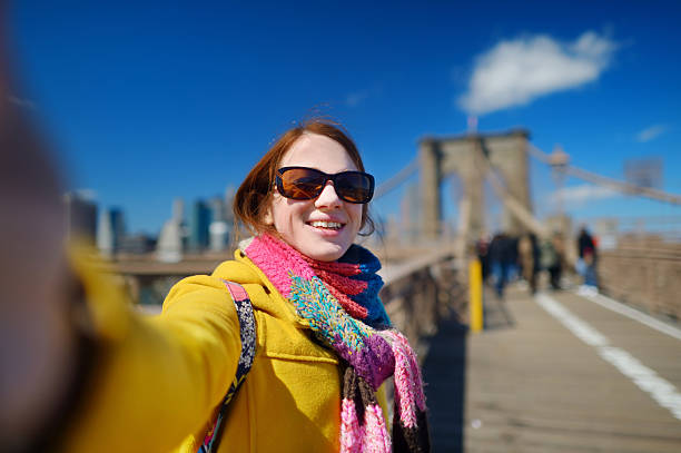 istock Young woman taking a selfie on Brooklyn Bridge 497750904