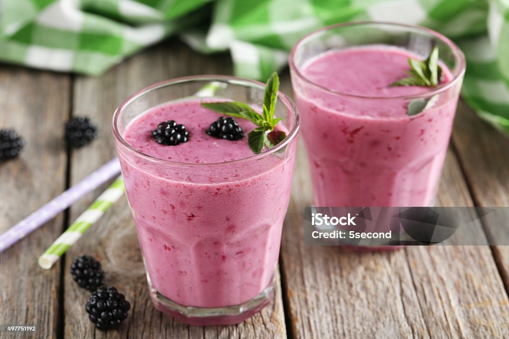 Blackberry smoothie in the glasses on grey wooden background 2015 Stock Photo