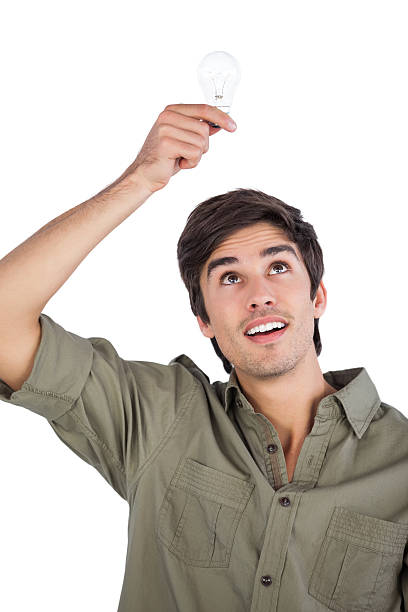 Man holding light bulb above his head Man holding light bulb above his head on a white background man with a light bulb over his head stock pictures, royalty-free photos & images