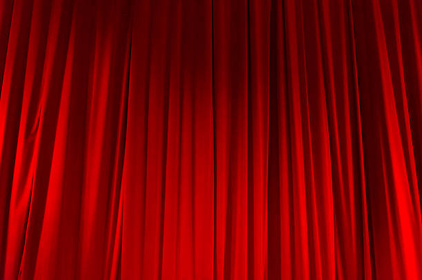 istock Red closed curtain with light spots in a theater 497752642