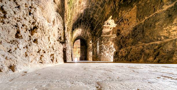 Crusader castle, Byblos, Lebanon Byblos, Lebanon - August 13, 2013: The interior of the crusaders' castle in the historic city of Byblos in Lebanon. A view of an indoor corridor, the walls and arrow loop through the museum gate. bailey castle photos stock pictures, royalty-free photos & images