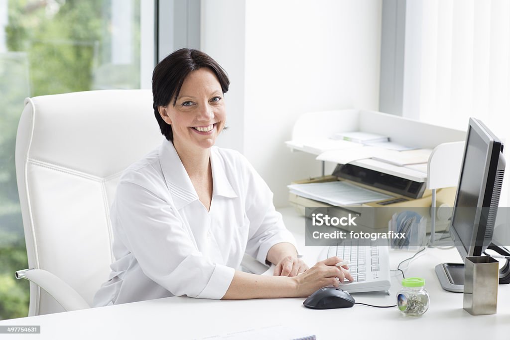 Femmina medico alla scrivania del computer - Foto stock royalty-free di 45-49 anni