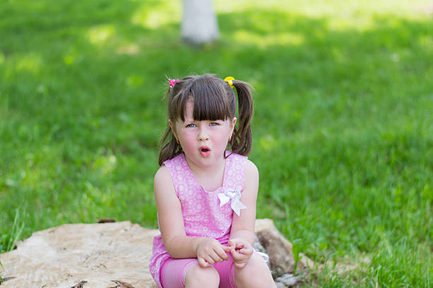 istock little girl in a park on a stump 497755365