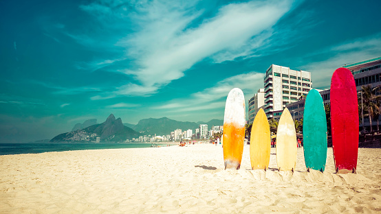 Surfboards standing upright in bright sun on the beach at Ipanema, Rio de Janeiro Brazil