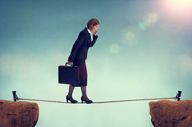 istock confident businesswoman walking a tightrope 497757403