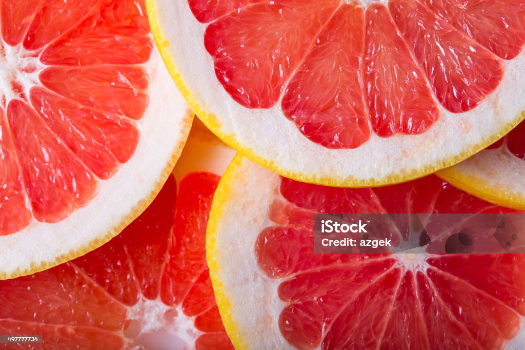 grapefruit background background made with a heap of sliced grapefruits Grapefruit Stock Photo