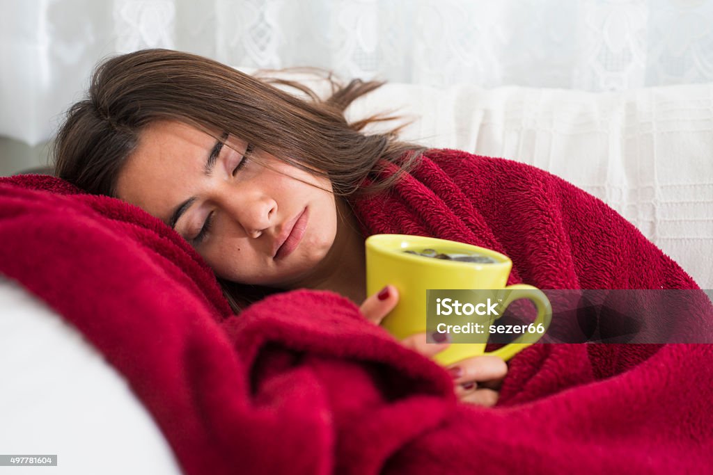 ill young girl with fever drinking cup of warm tea 2015 Stock Photo