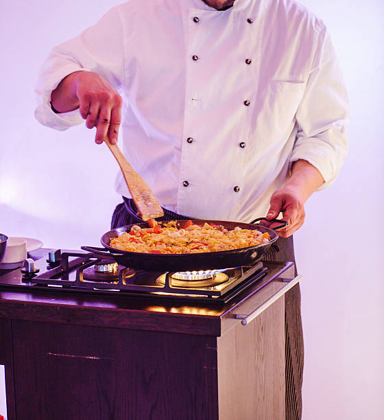 chef making paella stock photo