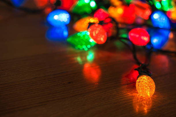 istock Multi-Colored Christmas lights on hardwood floor 497783932