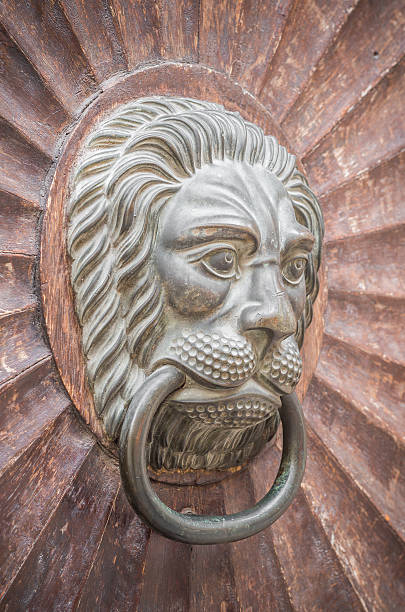 istock lion shaped knocker on the old wooden door 497785266