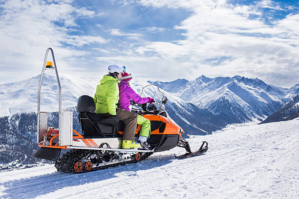 istock Young couple riding snowmobile snow mountain road 497786530