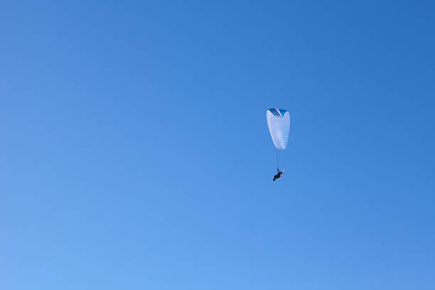 istock powered paragliding in the blue sky 497787762