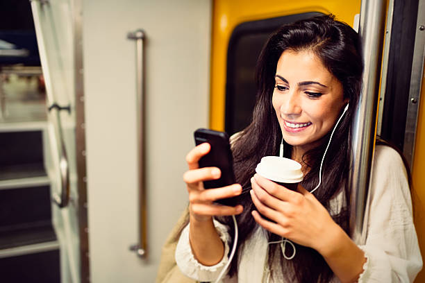 istock Young woman using a phone in subway train 497789290