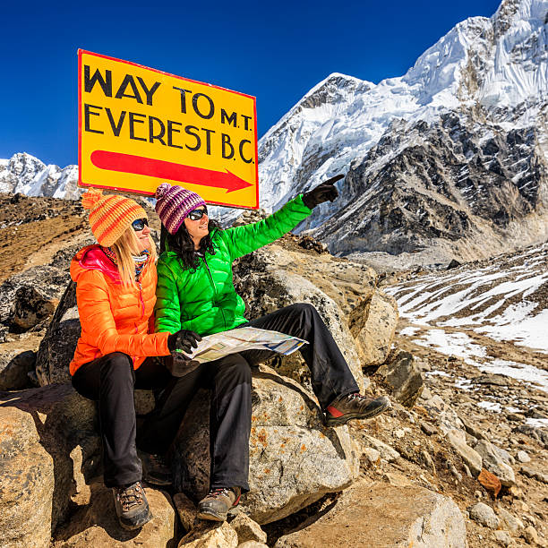 istock Young women studying map next to signpost, Nepali Himalaya 497790788