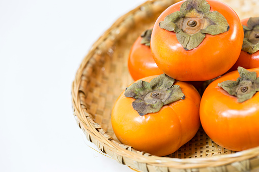 Fresh ripe persimmons on Japanese bamboo basket