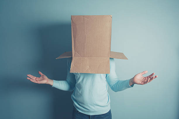 Confused man with cardboard box on his head stock photo