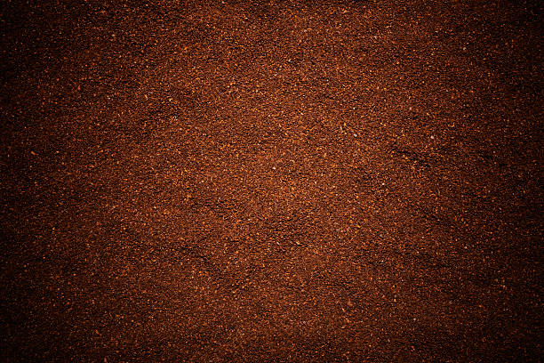 Close-up of ground coffee beans texture background. Close-up of ground coffee beans texture background with Spotlight. ground coffee stock pictures, royalty-free photos & images