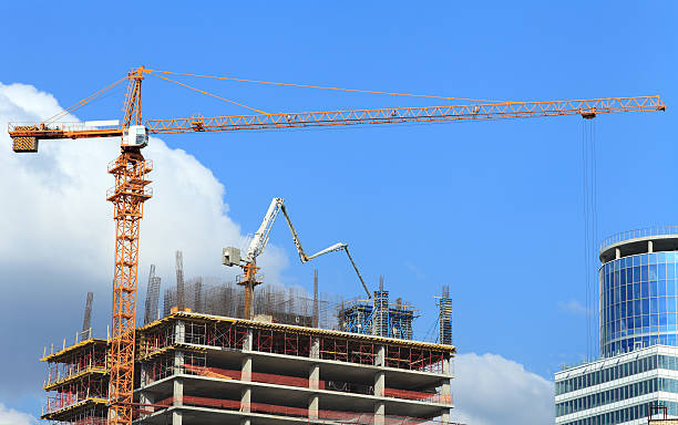 istock High-rise building under construction with crane and concrete pump. 497799725